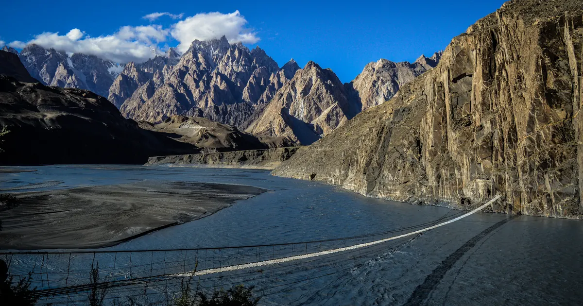 Hussaini-Hängebrücke über den Hunza-Fluss mit den zackigen Passu Cones dahinter, oberes Hunza im Karakorum