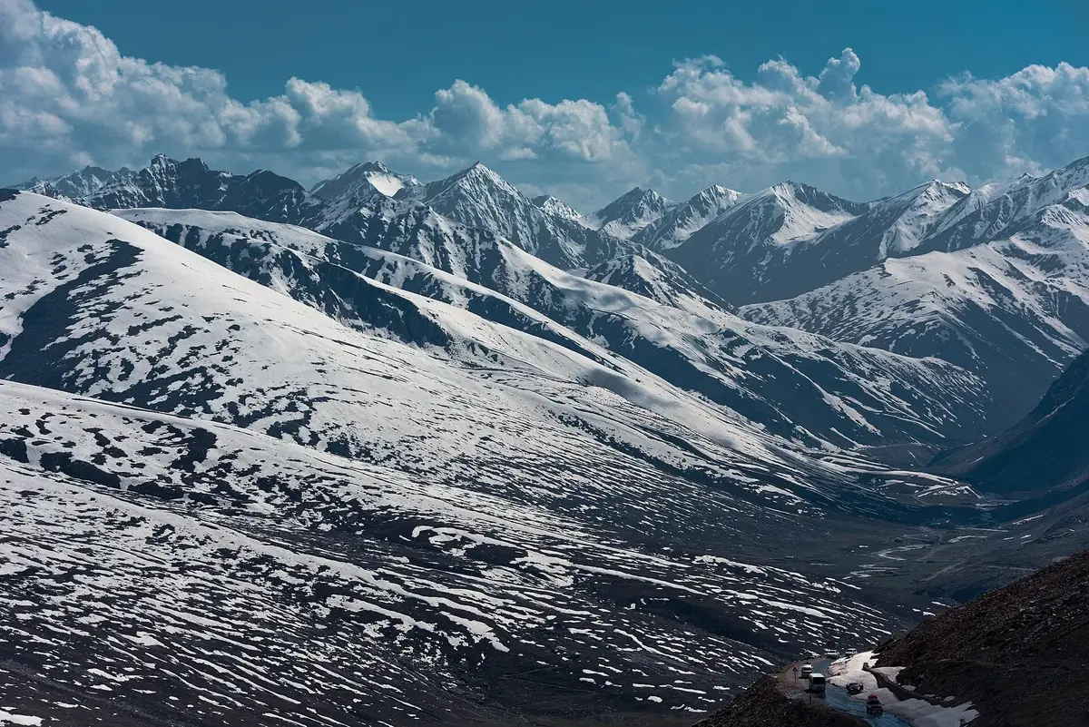 Snow-covered mountains above the Babusar Top road with vehicles descending, Gilgit-Baltistan, Pakistan