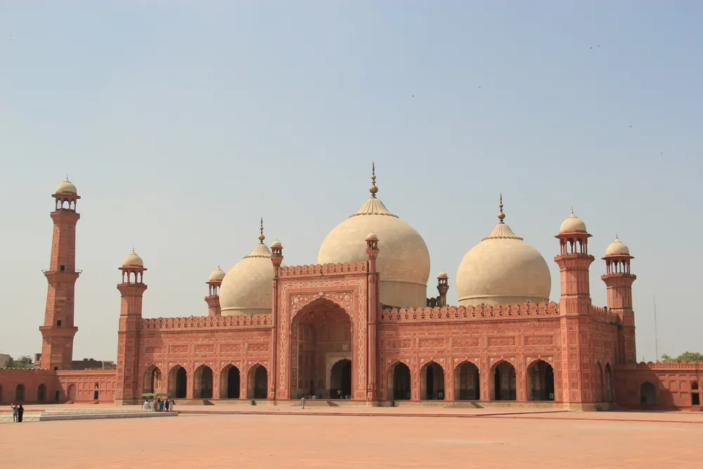 The red sandstone Badshahi Mosque with its white domes in the Walled City of Lahore, Pakistan