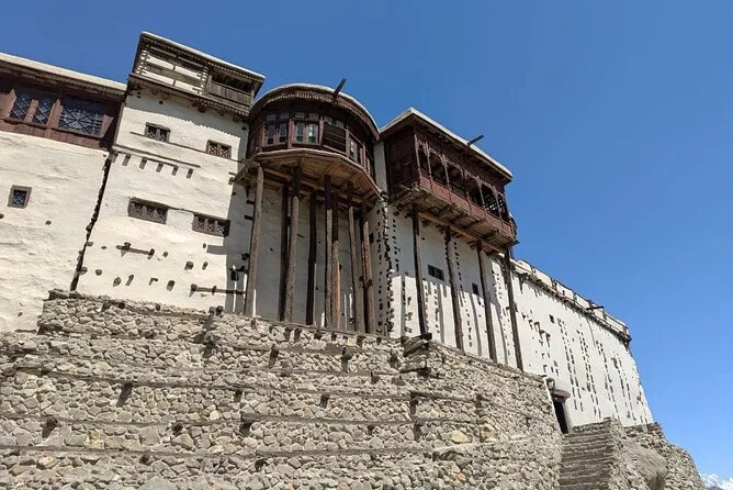 Il Forte Baltit a Karimabad, Hunza, con i balconi in legno intagliato che si protendono sopra le terrazze di pietra contro un cielo azzurro