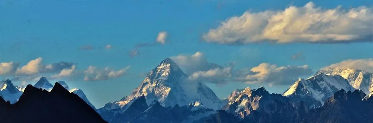 La pyramide du K2 s'élève au-dessus de la ligne d'horizon du Karakoram à l'aube, panorama vu depuis le point de vue sur le K2 du trek de Barah Broq, au Moses Peak au Pakistan