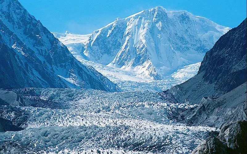 Il vasto ghiaccio crepacciato del ghiacciaio del Batura sotto una vetta innevata del Karakorum, uno dei ghiacciai non polari più lunghi al mondo, alta Hunza