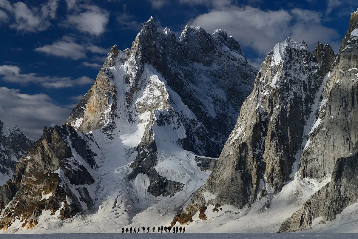 Pejalan trekking dan porter di glasier Biafo menuju Snow Lake
