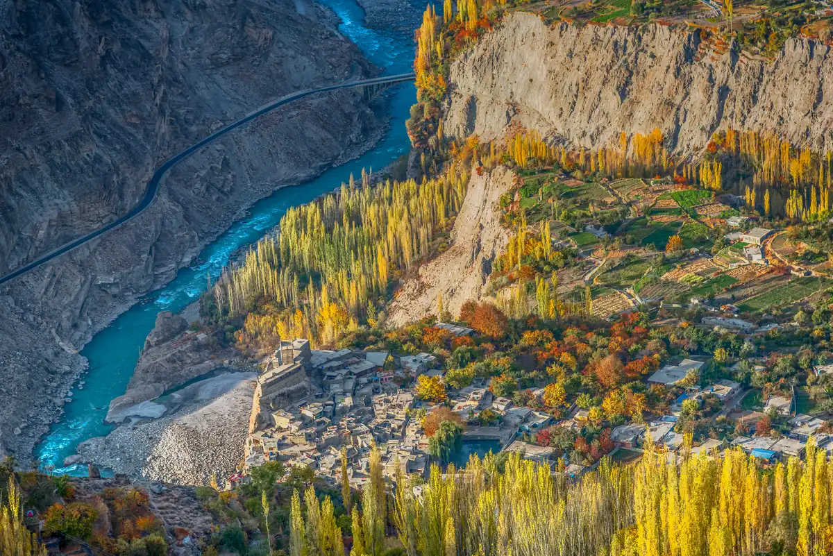 Herbstlicher Sonnenaufgang am Eagle's Nest in Duikar mit Blick hinab auf den türkisfarbenen Hunza-Fluss und goldene Pappeln