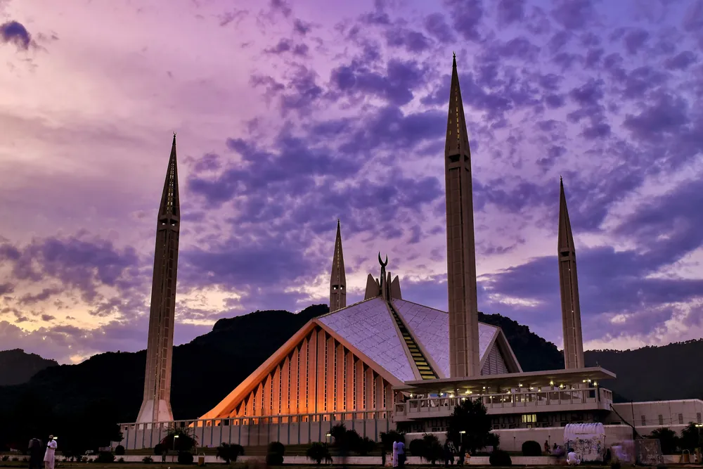 The modernist white Faisal Mosque below the green Margalla Hills in Islamabad, Pakistan