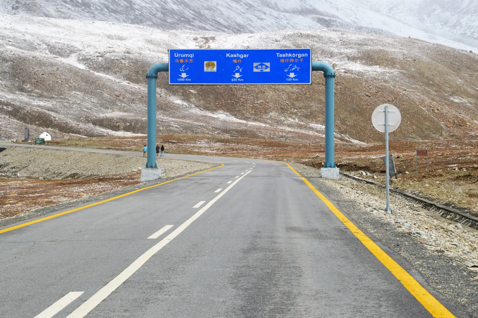 La Karakoram Highway in avvicinamento al passo Khunjerab al confine Pakistan-Cina, con il cartello stradale trilingue per Kashgar e Tashkorgan, Gilgit-Baltistan, Pakistan