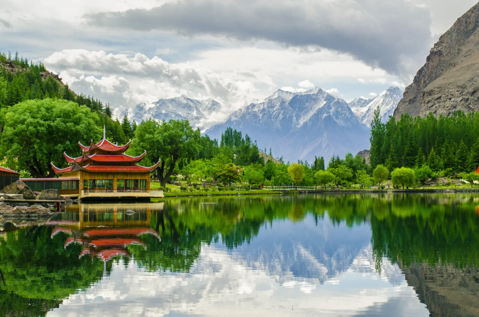 La pagoda rossa del resort di Shangrila riflessa nel lago inferiore di Kachura, con cime innevate, Skardu, Baltistan, Gilgit-Baltistan, Pakistan