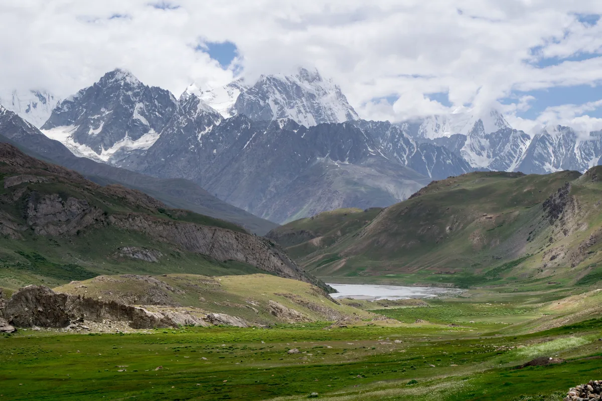Koyo Zom and the Hindu Raj peaks above the green meadows of Broghil Valley, upper Chitral, Pakistan