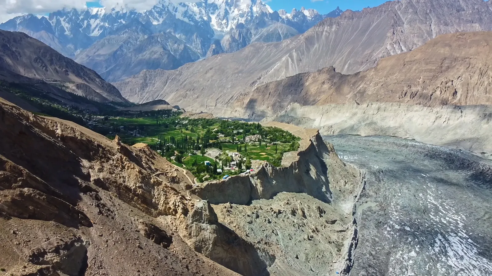 Veduta aerea della verdeggiante valle di Hopar a Nagar con il grigio ghiacciaio di Hopar (Bualtar) che si snoda sotto le frastagliate vette del Karakorum