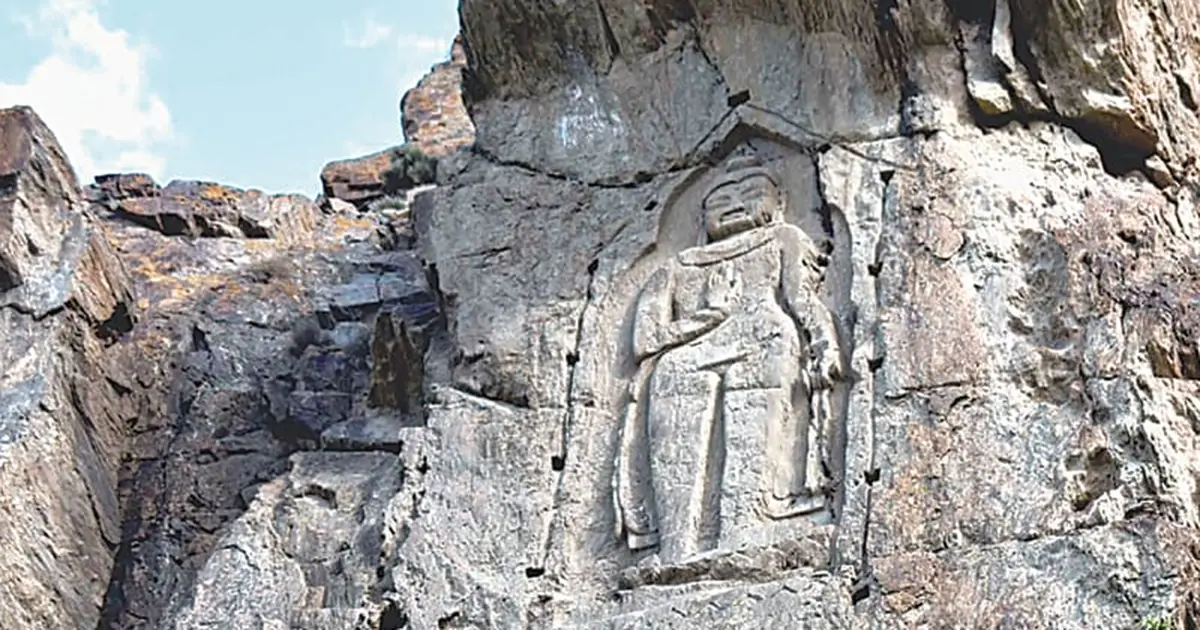 The Kargah Buddha, a 7th-century standing Buddha carved in relief high on a grey cliff face west of Gilgit, Gilgit-Baltistan