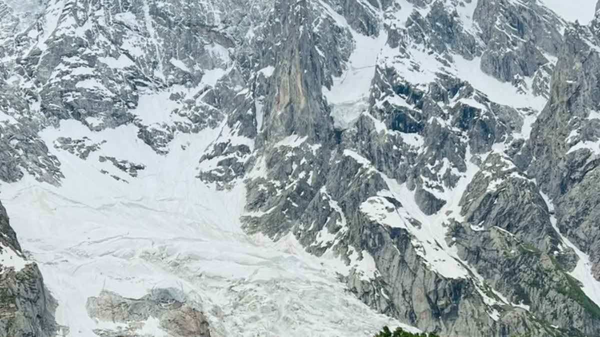 Goats and cattle grazing the summer meadow at Kutwal below the glaciated north face of Haramosh Peak, Gilgit-Baltistan