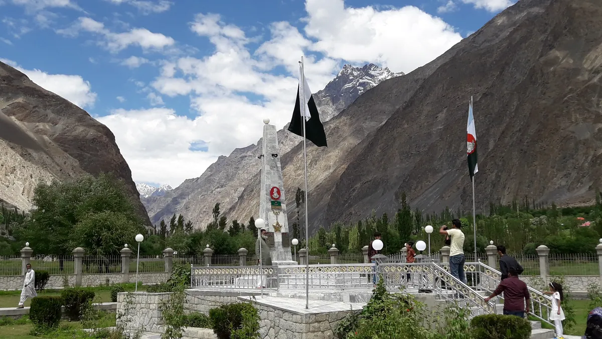 The white memorial of Havaldar Lalak Jan, Nishan-e-Haider, in a garden with Pakistani flags at Hundur village, Yasin Valley, Gilgit-Baltistan, Pakistan