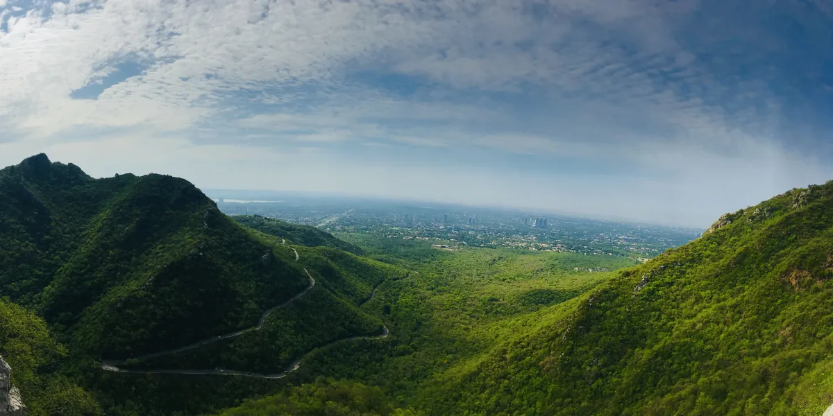 Forested ridges of Margalla Hills National Park with Islamabad spread on the plain beyond, Pakistan