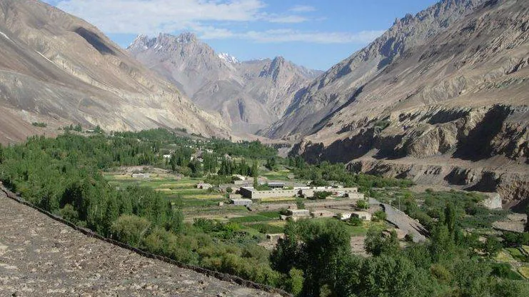 Il villaggio di Misgar nell'alto Gojal, valle di Hunza, visto dall'alto, con campi verdi e pioppi sul fondovalle e le creste spoglie del Karakorum alle spalle, Gilgit-Baltistan, Pakistan