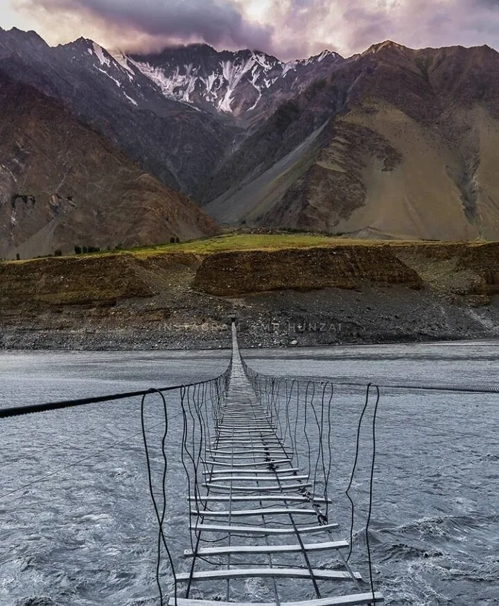 Blick über das Plankendeck der Passu-Hängebrücke über den Hunza-Fluss, dahinter Karakorum-Gipfel, Gojal, oberes Hunza
