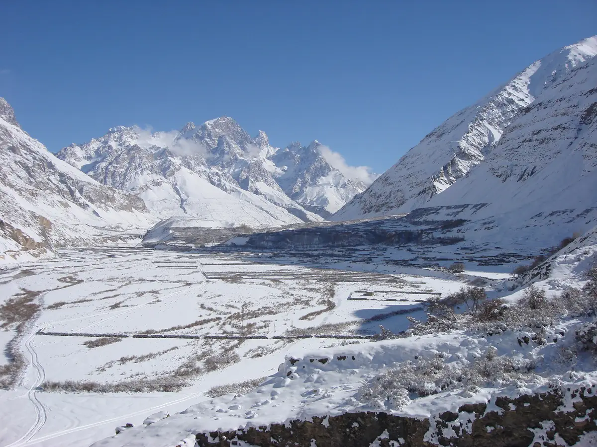 The Shimshal valley under deep winter snow with the river frozen and peaks above, Gojal, Hunza