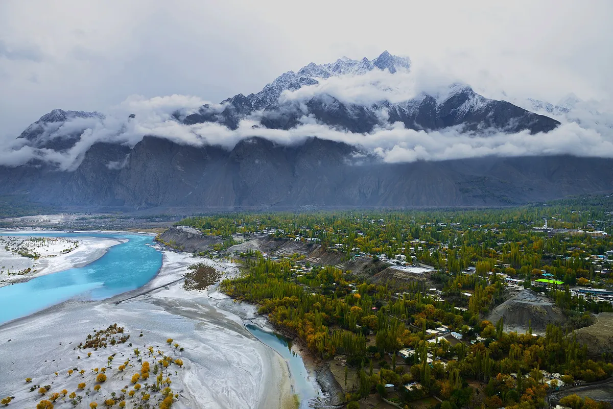Skardu town in autumn seen from Kharpocho Fort, with golden poplars, the braided Indus River and snowy peaks