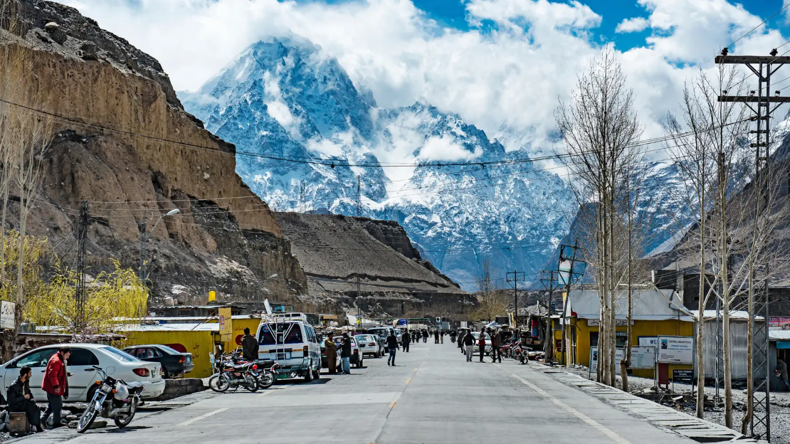 La via principale di Sost, l'ultima cittadina dell'alta Hunza prima del confine con la Cina, con negozi e vette innevate sullo sfondo