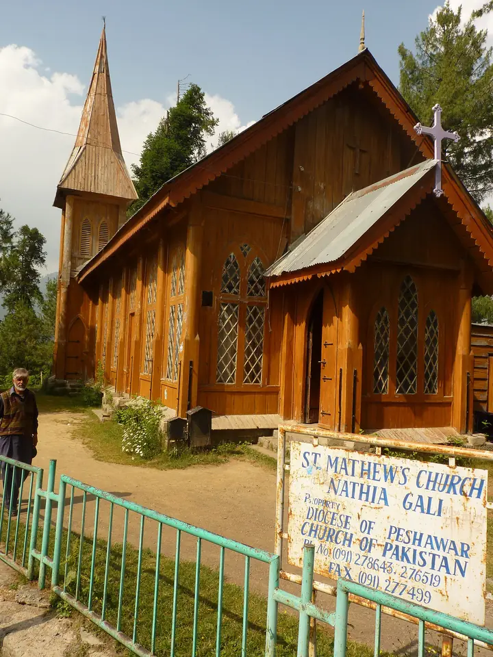 St.-Matthäus-Kirche, eine Holzkirche aus der Kolonialzeit mit spitzem Turm, neben ihrem Schild in Nathia Gali, Khyber Pakhtunkhwa, Pakistan