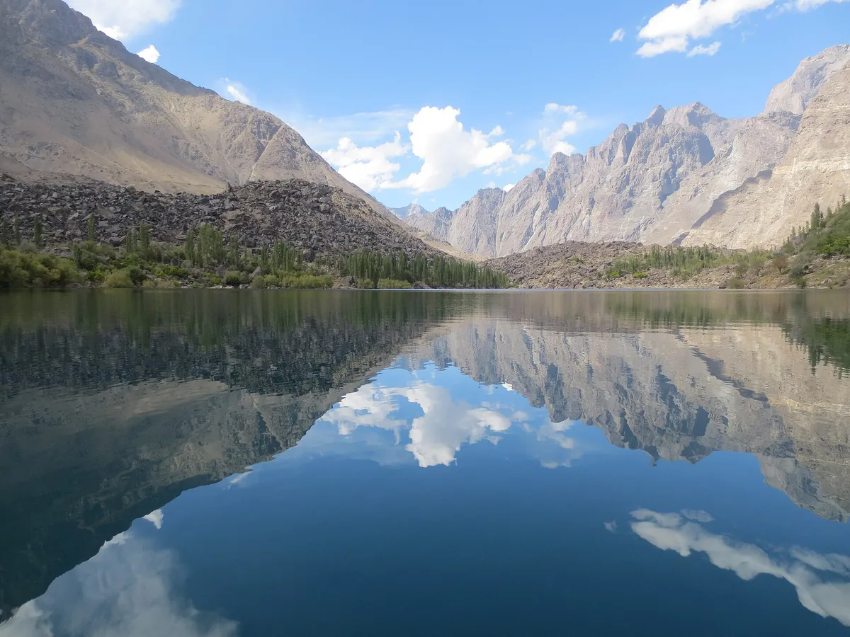 Upper Kachura Lake near Skardu with jagged Karakoram peaks and blue sky reflected in its deep, clear water
