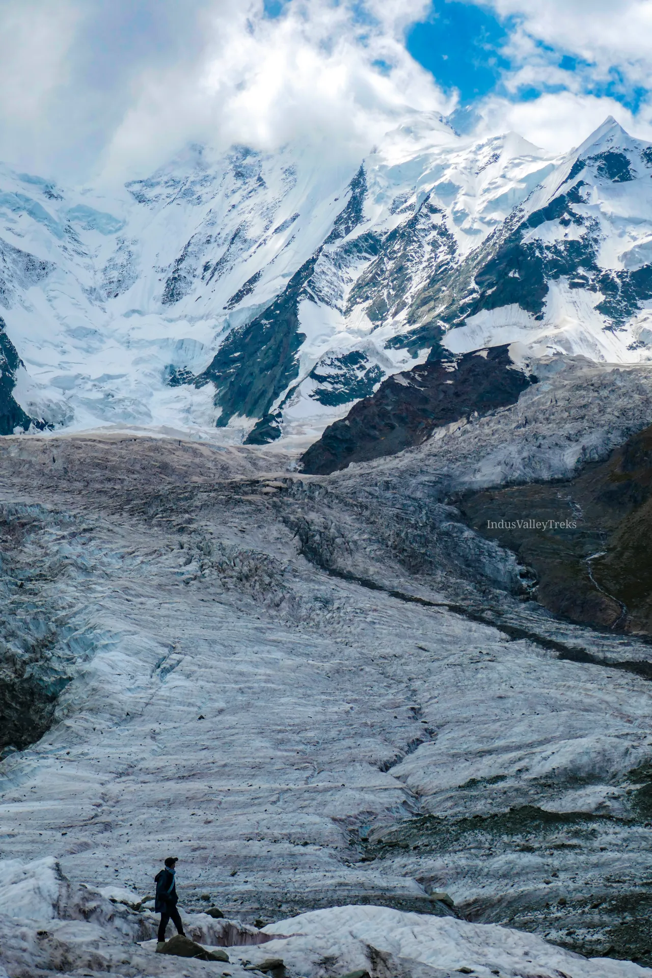 Trekker crossing the glacier beneath Rakaposhi, Hunza-Nagar, Pakistan