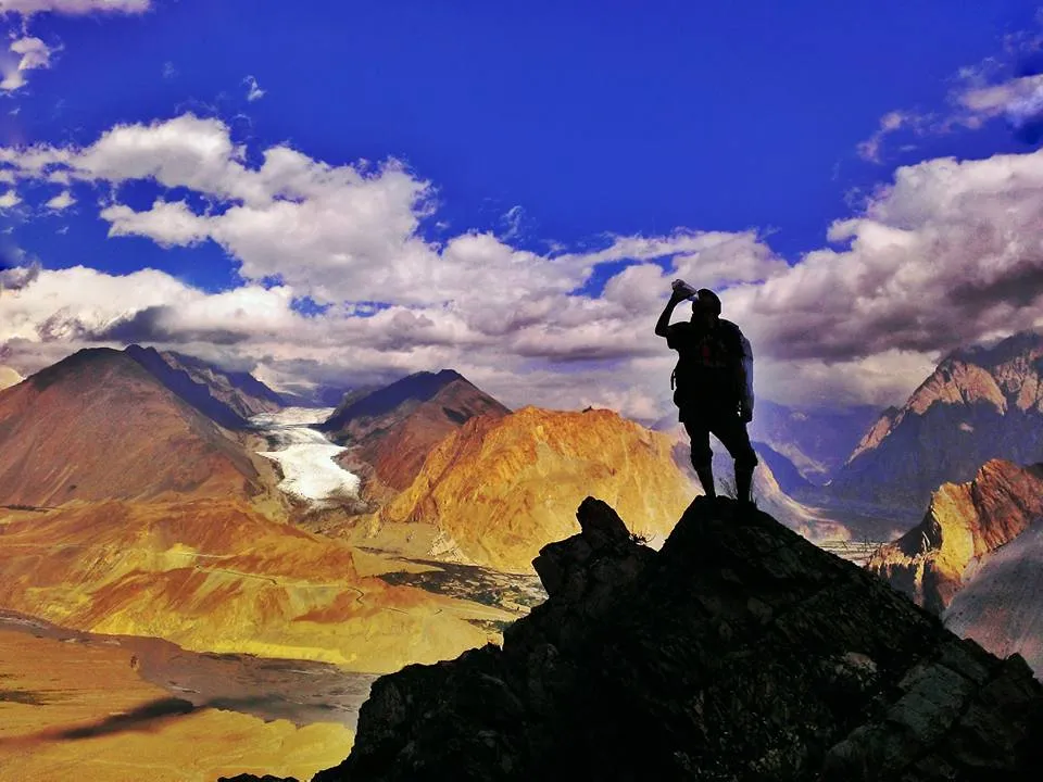 A trekker on a ridge above the Batura Glacier at sunrise