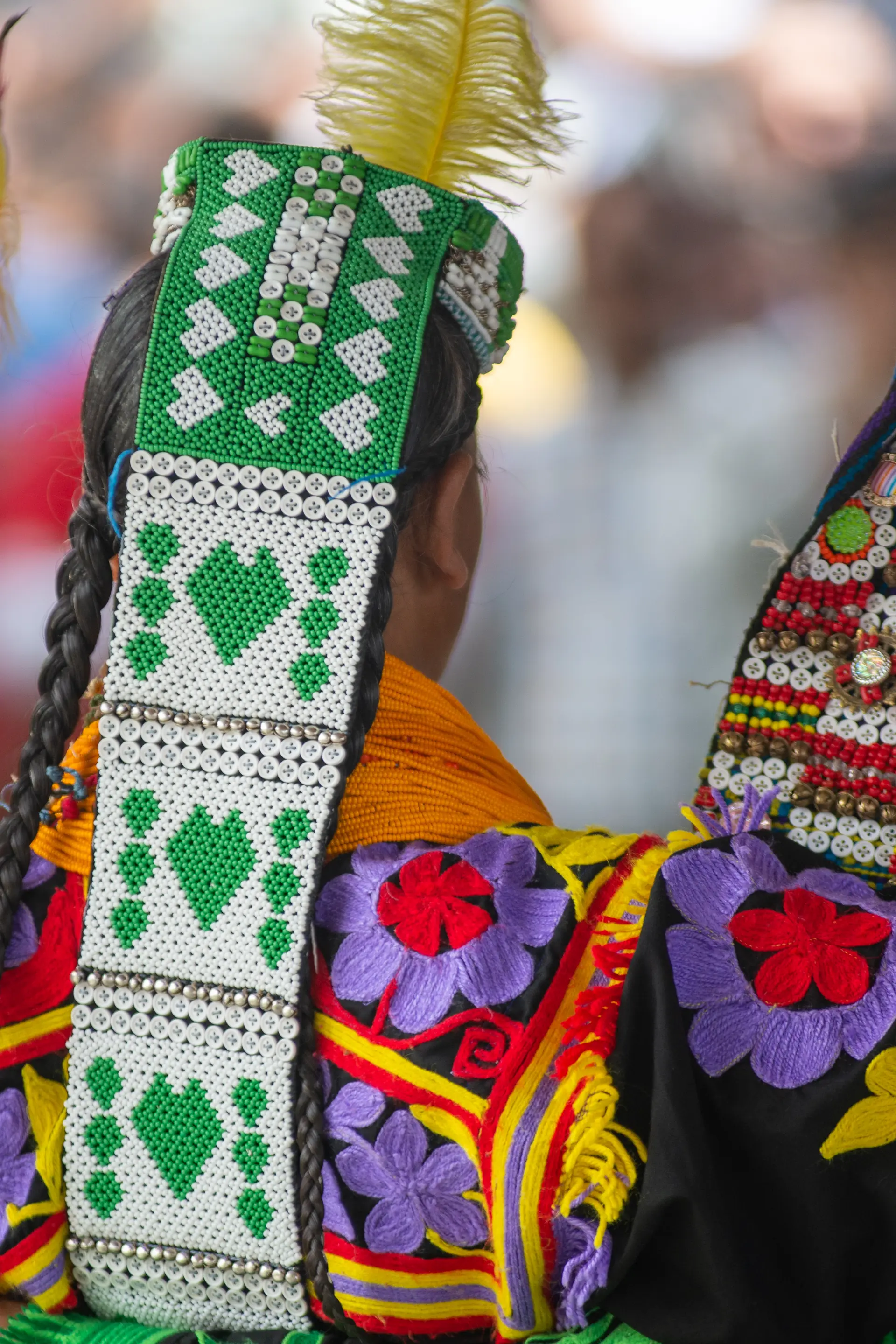Embroidered headdress and colourful robes of a Kalash dancer at the spring festival