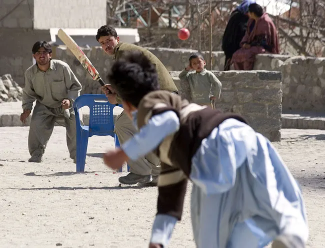 Local children playing cricket in a mountain village