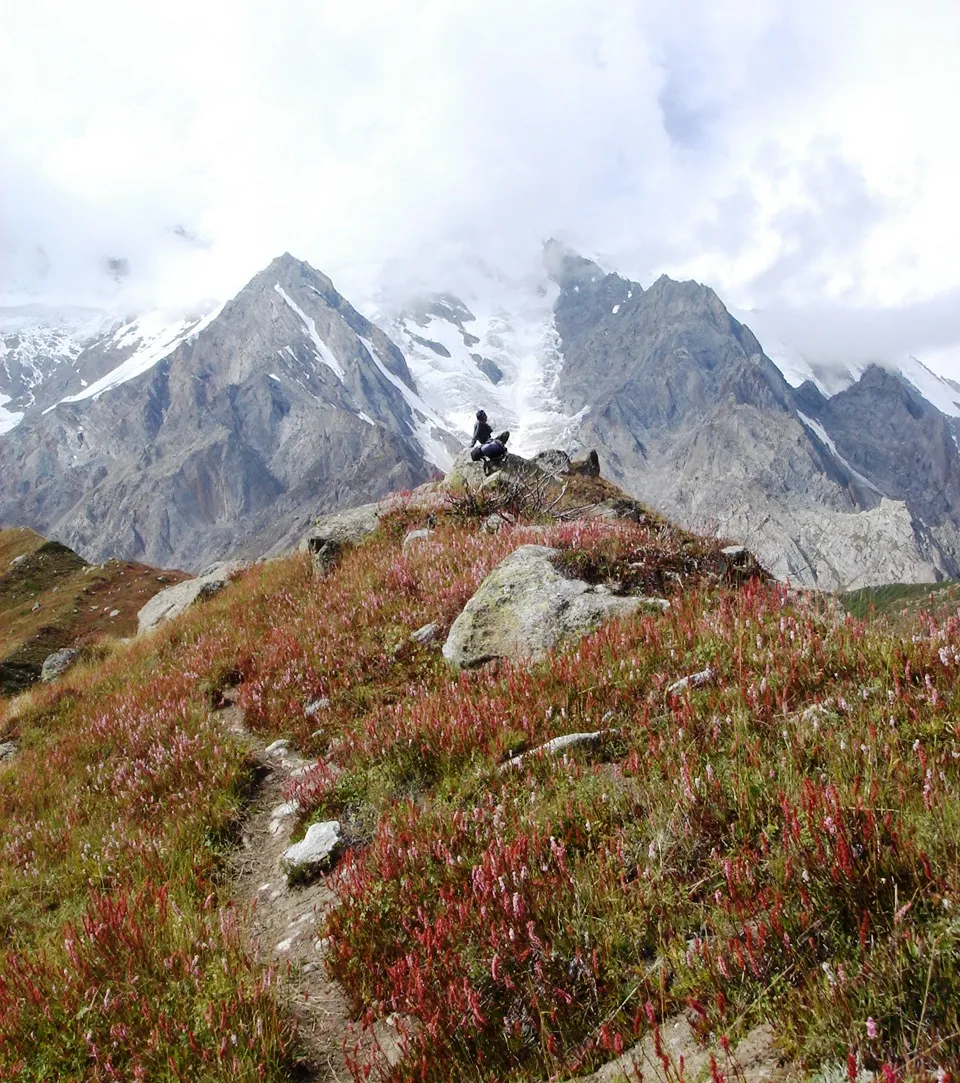 A hiker on the autumn trail toward Nanga Parbat base camp above Fairy Meadows