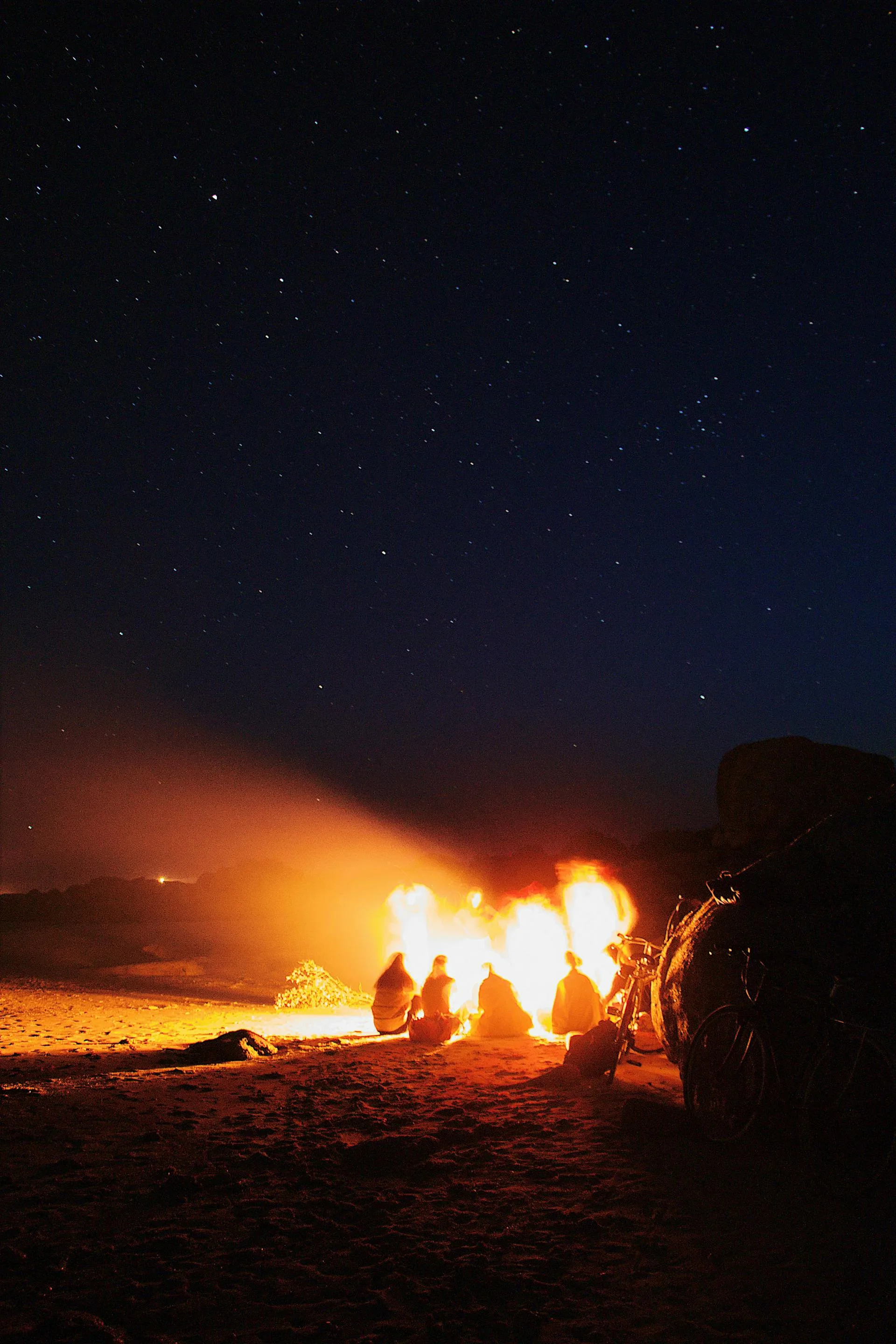 People around bonfire under starry sky