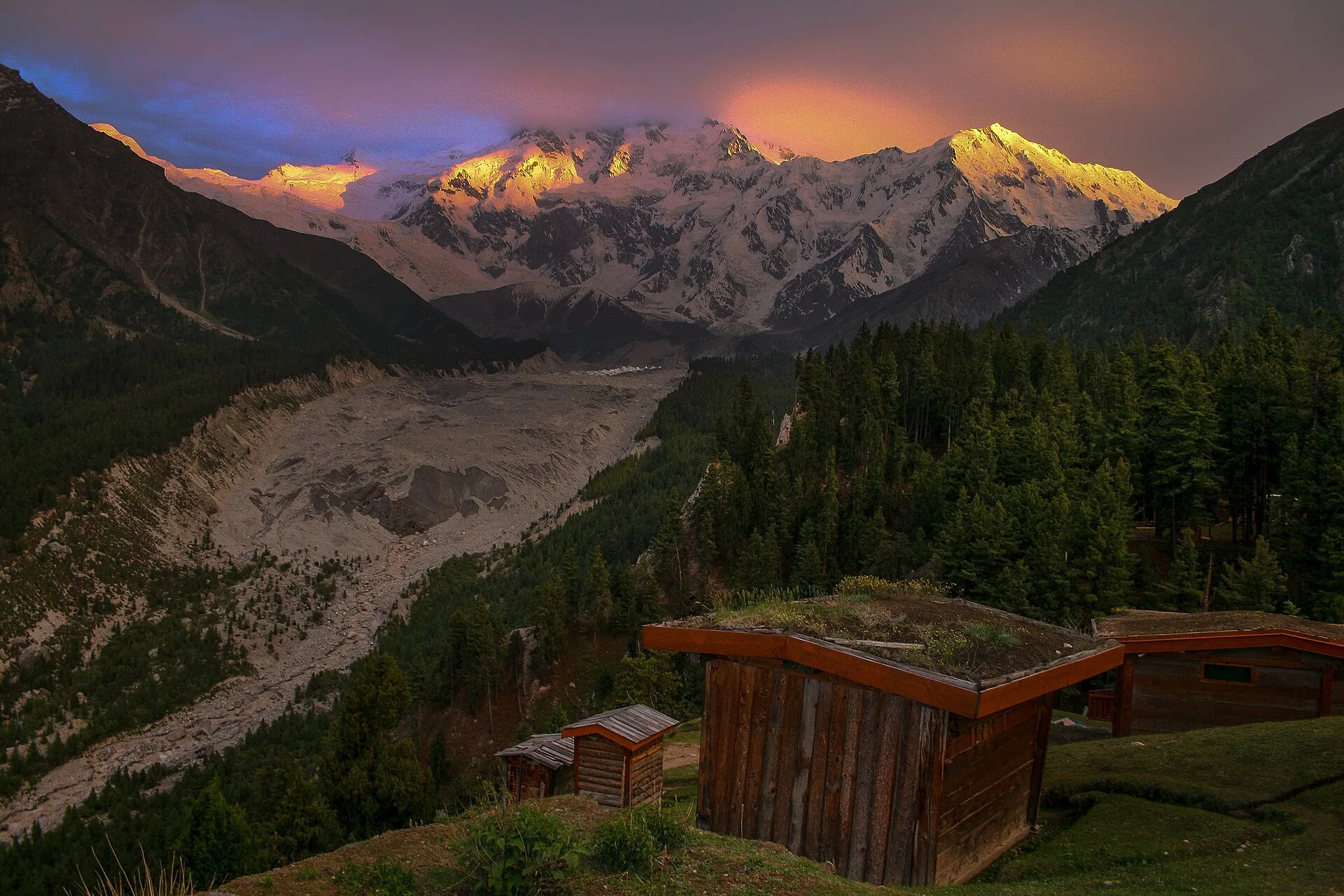 Golden sunset light on Nanga Parbat above a wooden cabin at Fairy Meadows