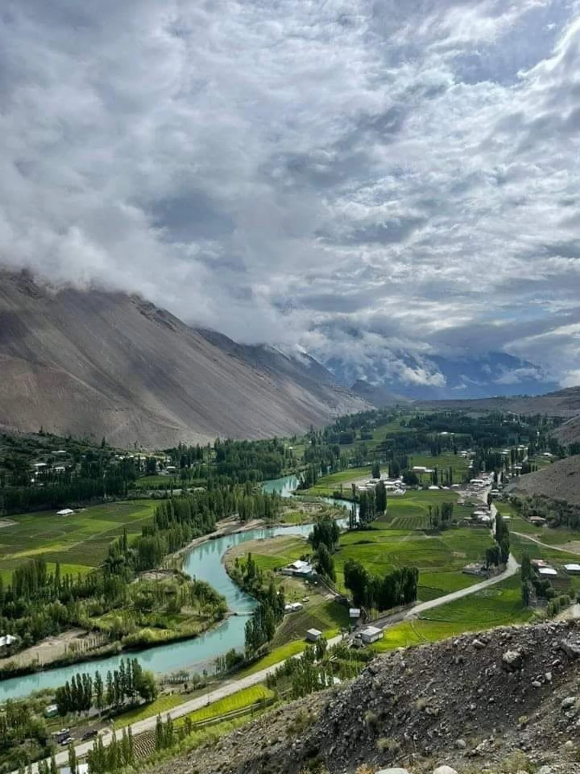 The Ghizer River splitting into braided turquoise channels across the valley floor