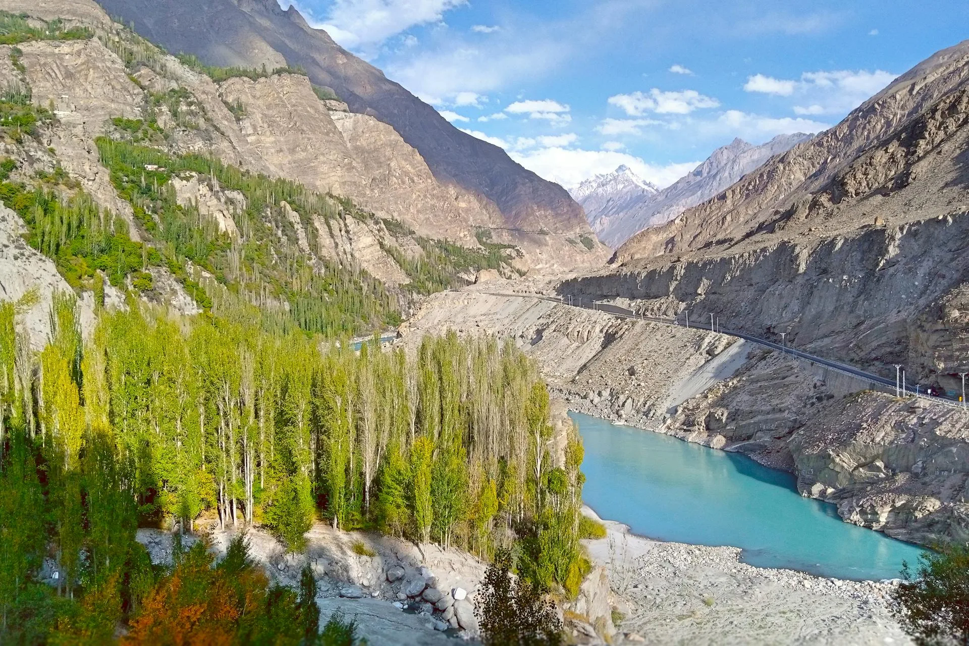 A lush green river valley surrounded by towering mountains