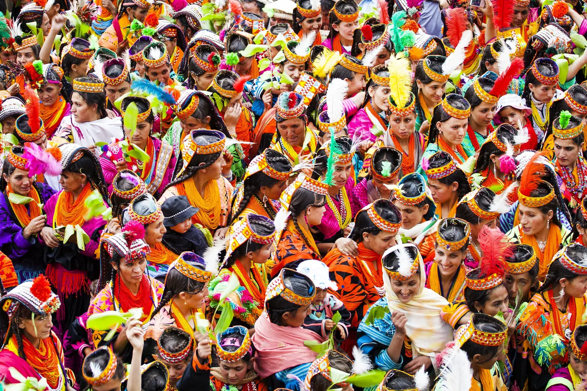 Kalash women in feathered headdresses at the Chilam Joshi spring festival in Chitral