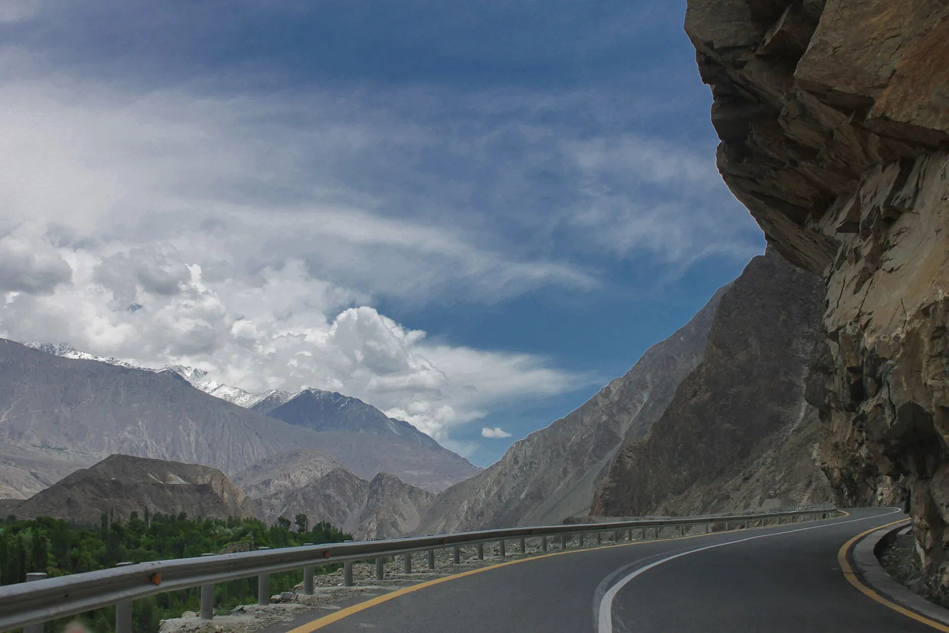 A guard-railed bend of the Karakoram Highway below snow-dusted peaks