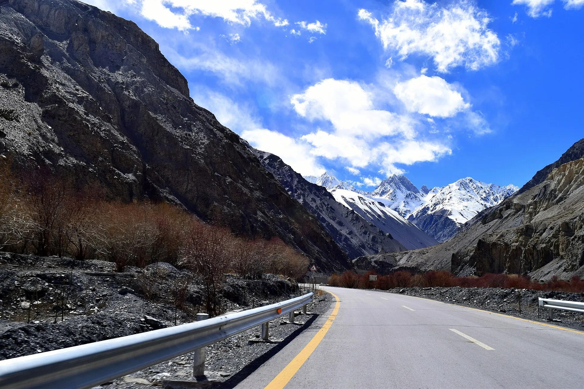 The Karakoram Highway curving beneath snow-capped mountains