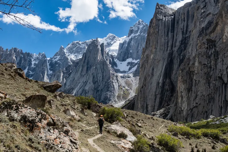 A trekker on the trail into Nangma Valley beneath a granite wall, Hushe, Baltistan