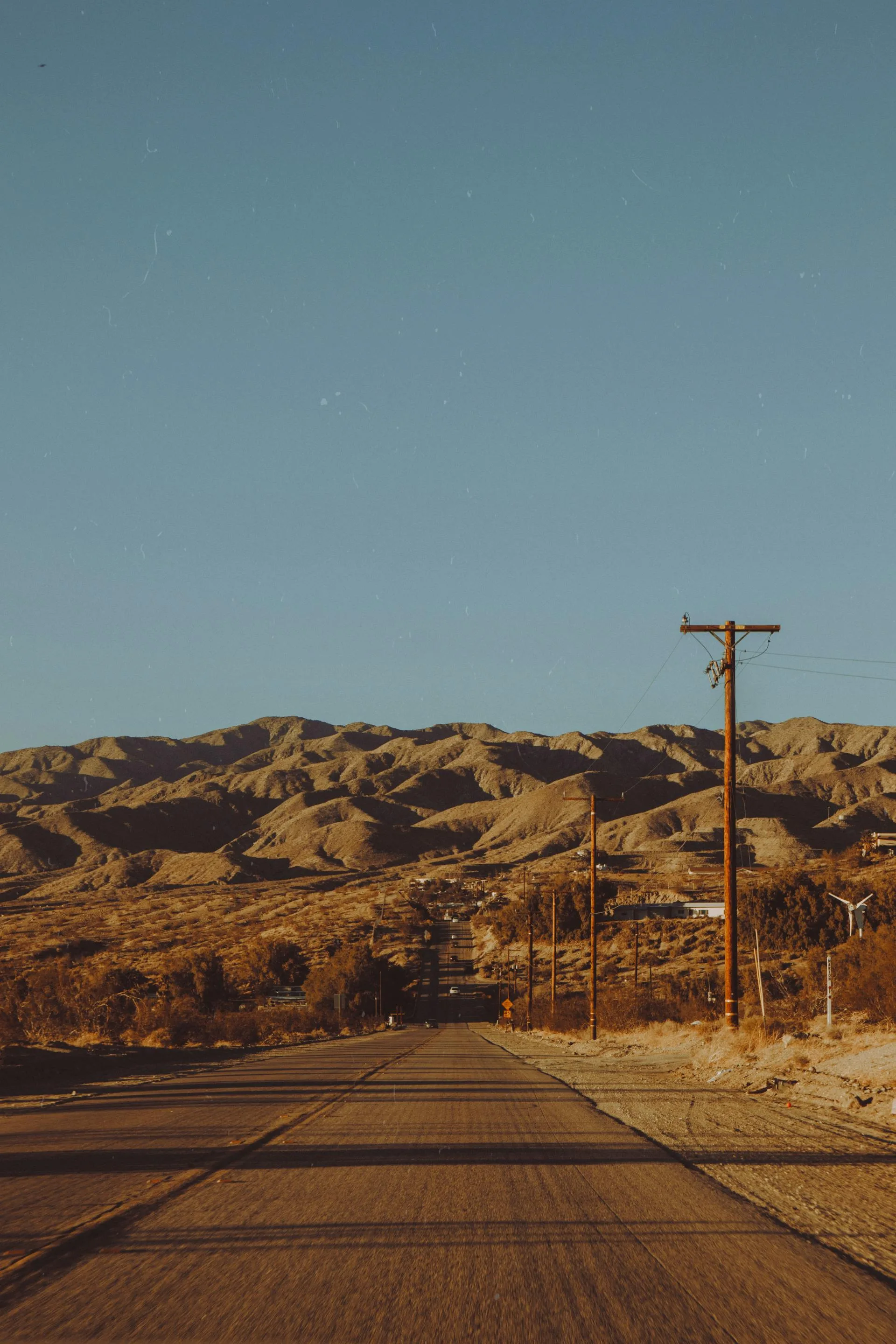 Road through desert to barren mountains