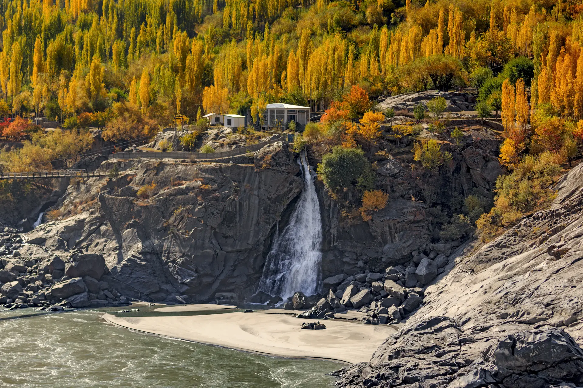 A roadside waterfall on the Gilgit-Skardu road framed by autumn colours