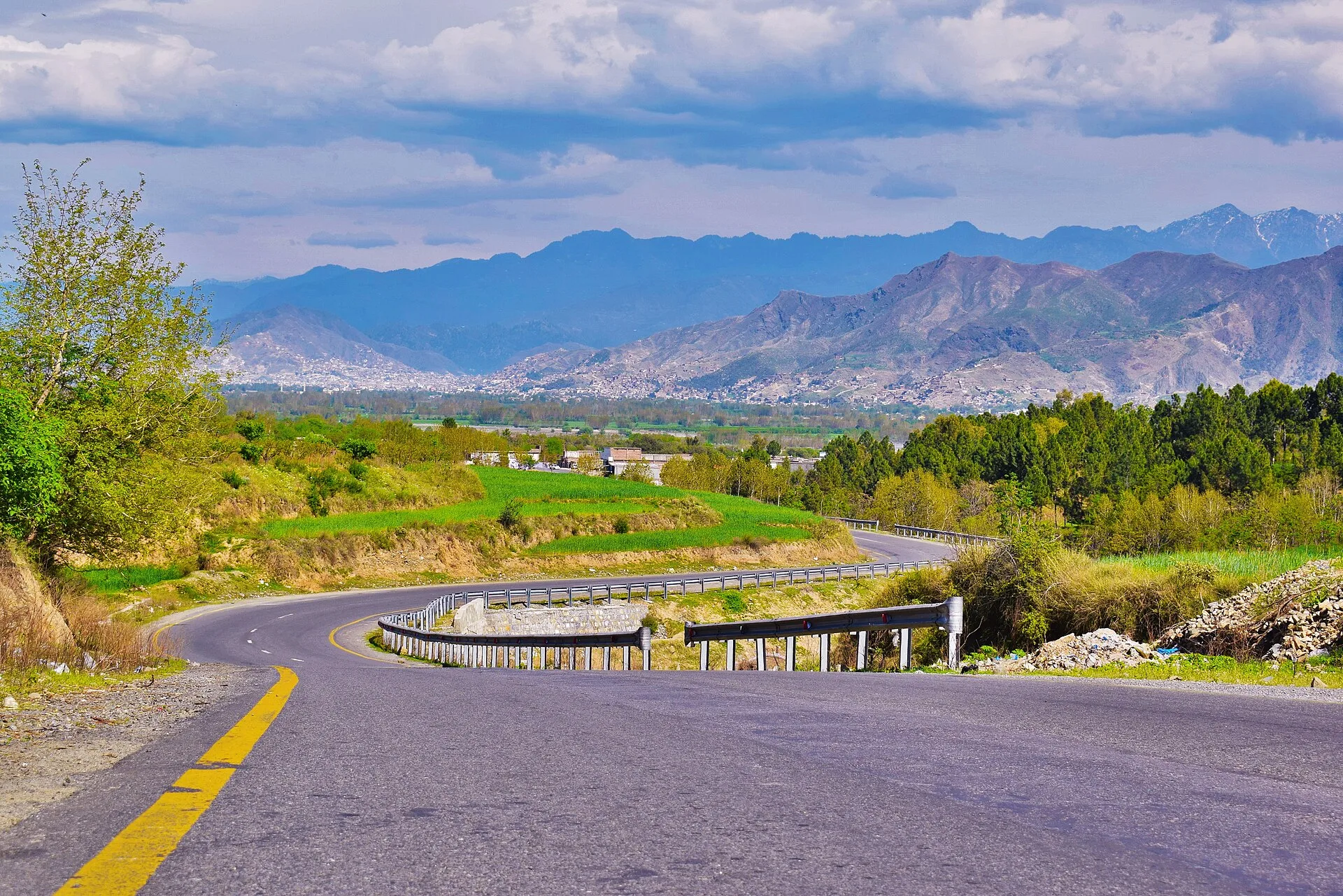 A road through the green Swat Valley below the mountains