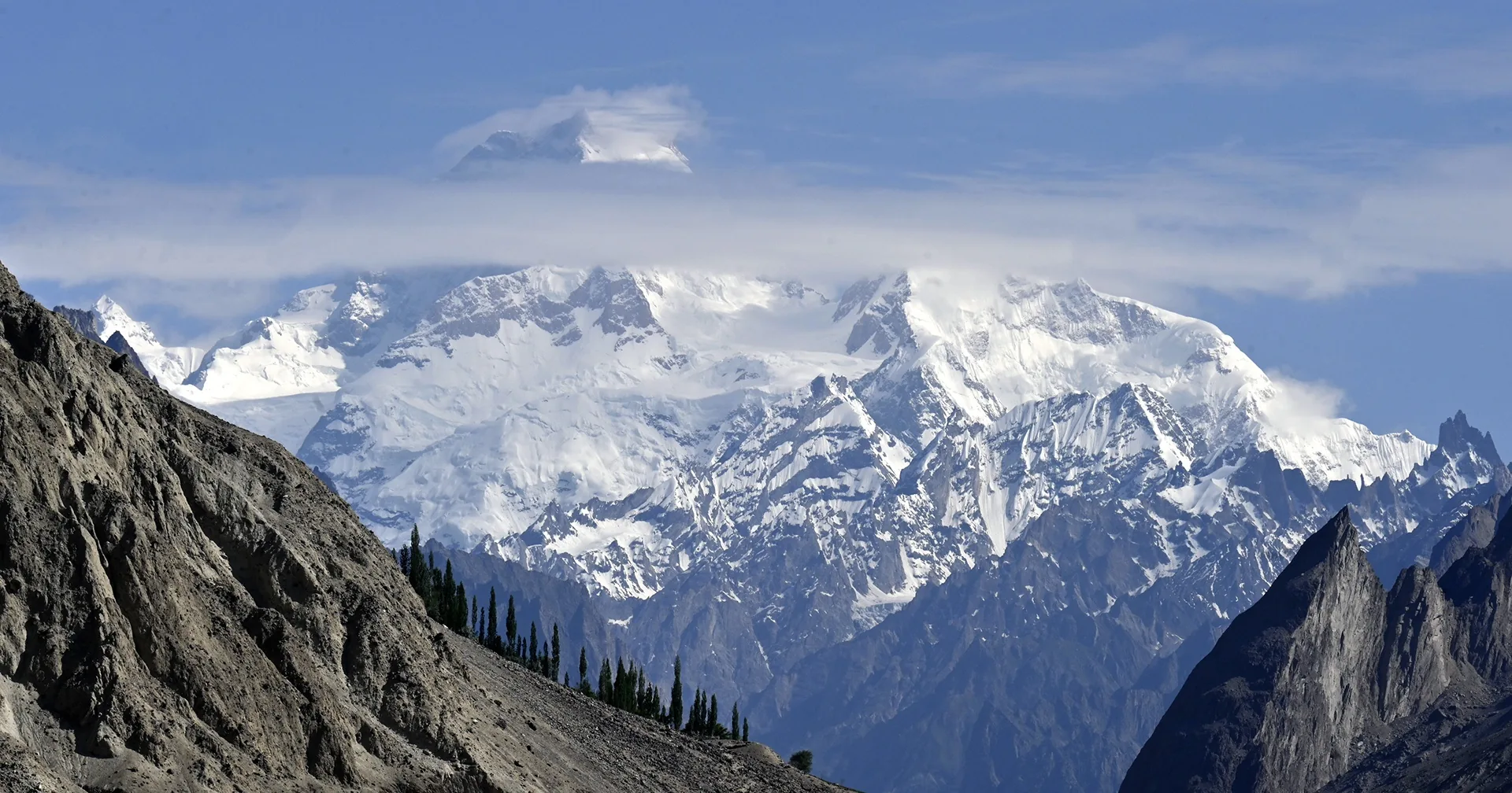 Masherbrum (7,821 m) above the brown ridges and poplars of the Hushe valley, the peak seen from Thalle La