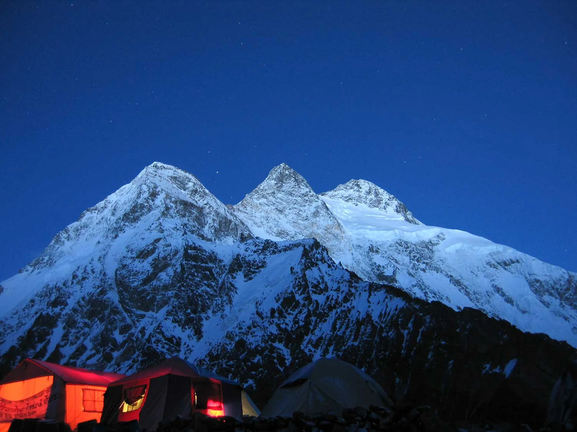 Broad Peak base camp at night with illuminated tents and starry sky Karakoram Pakistan