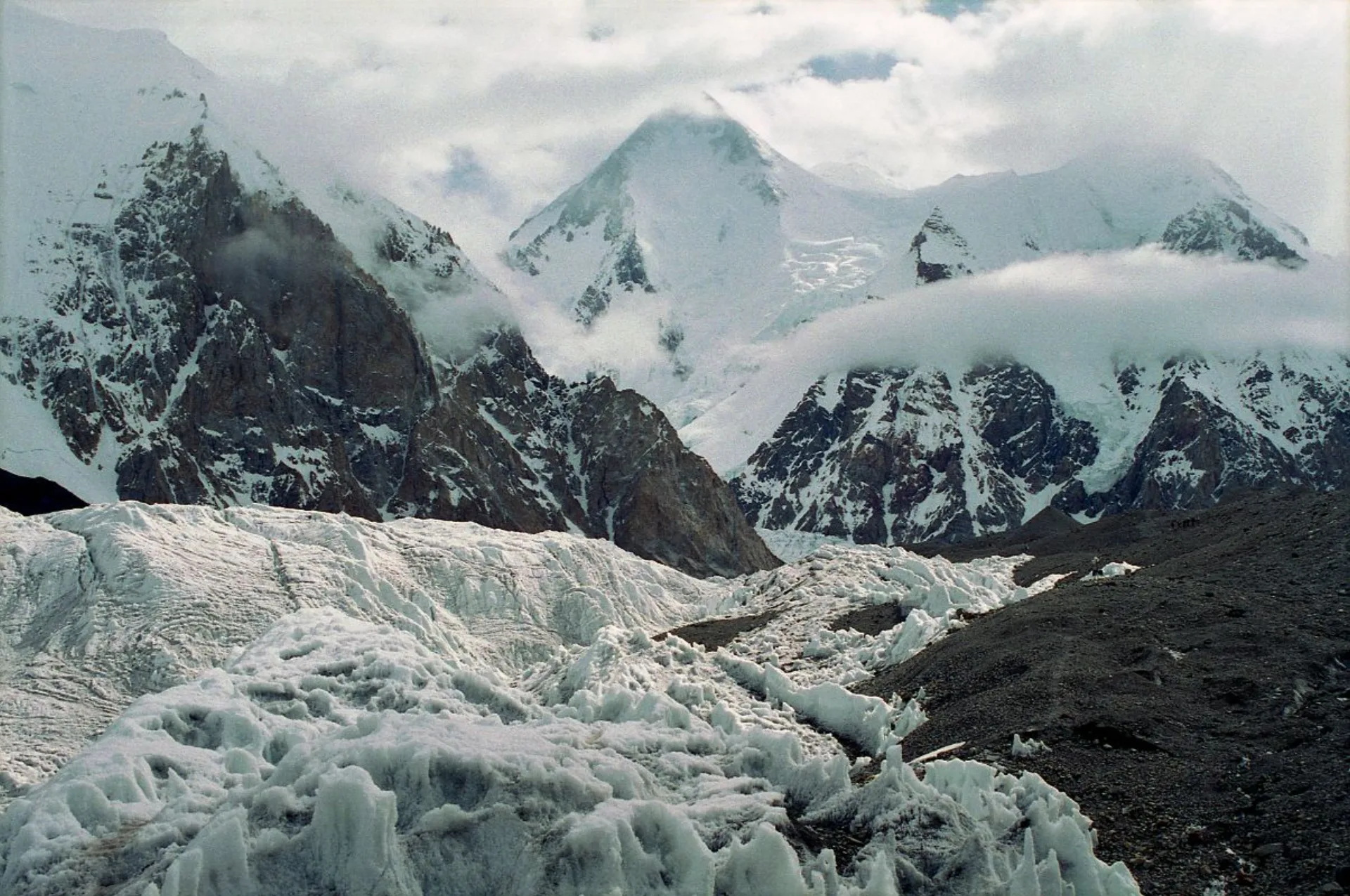 Gasherbrum I viewed from Abruzzi Glacier with massive icefall and rocky spires in foreground, Baltoro Pakistan