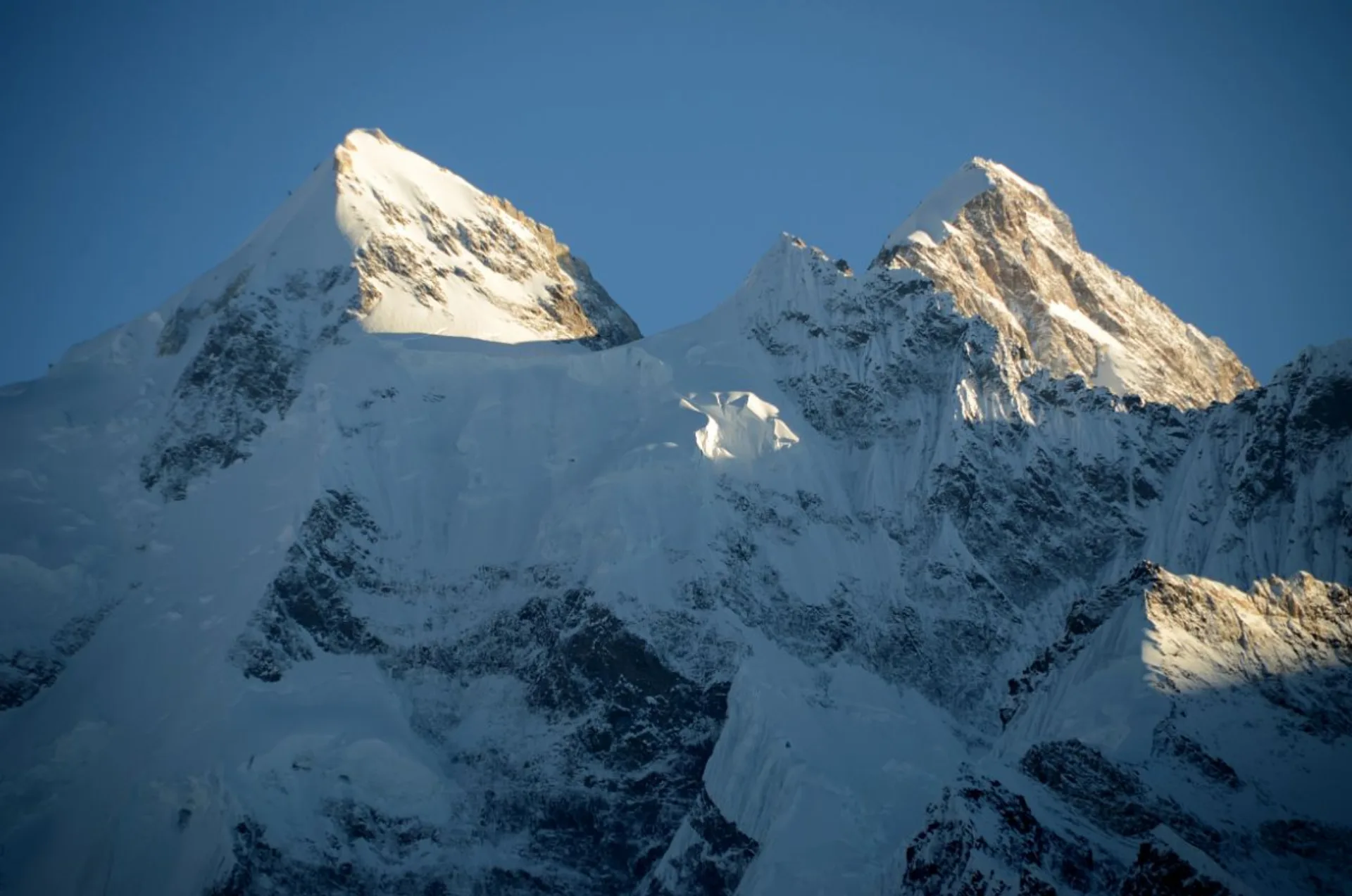 Gasherbrum II 8035m and Gasherbrum III north faces close-up with golden sunlight on twin summits, Karakoram Pakistan