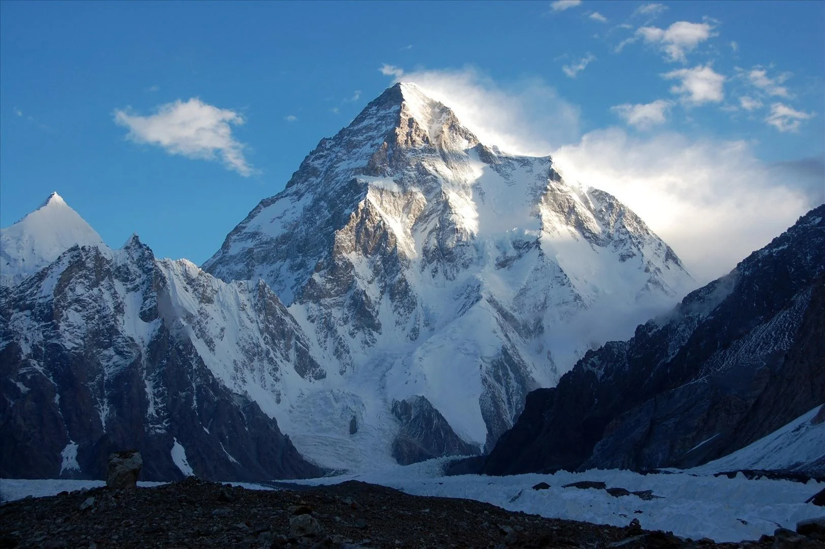 K2 Savage Mountain at dawn with clouds swirling around the summit pyramid, Baltoro Glacier Pakistan