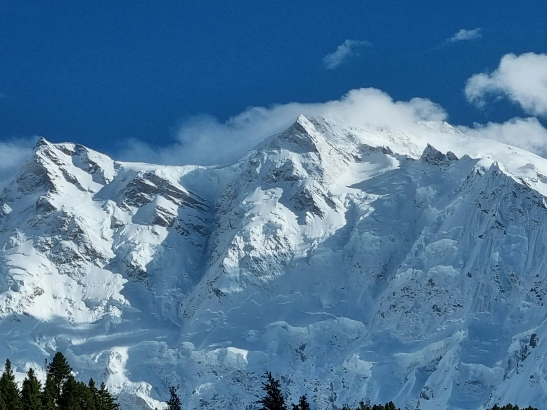Nanga Parbat summit peak emerging above thick white clouds, 8126m the ninth highest mountain